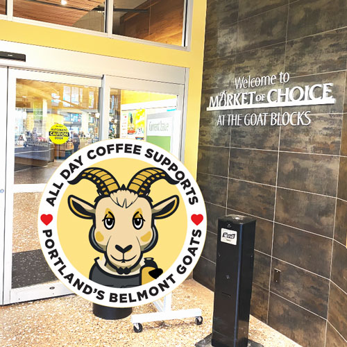 a cute cartoon goat logo over the entrance to Market Of Choice at the Goat Blocks
